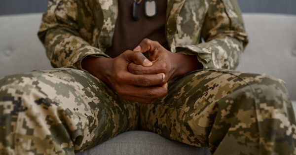 Closeup hands of soldier in military uniform. Mental problem, ptsd, psychological disorder treatment